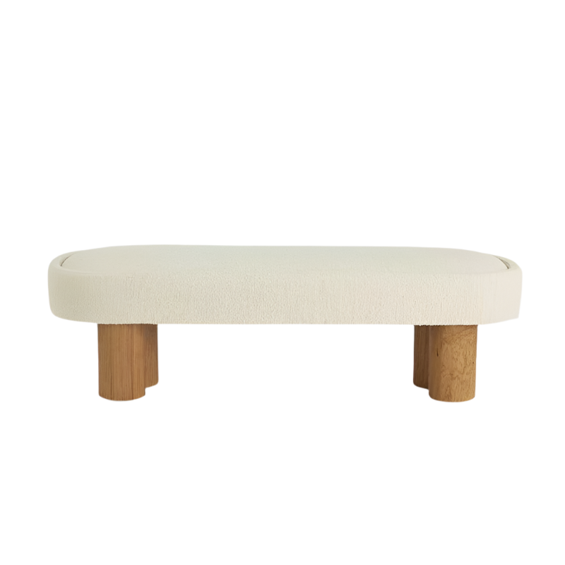 59-inch end-of-bed bench upholstered in natural cream boucle fabric with a rounded rectangular cushion and low-profile coastal-contemporary silhouette supported by chunky solid wood cylindrical legs.