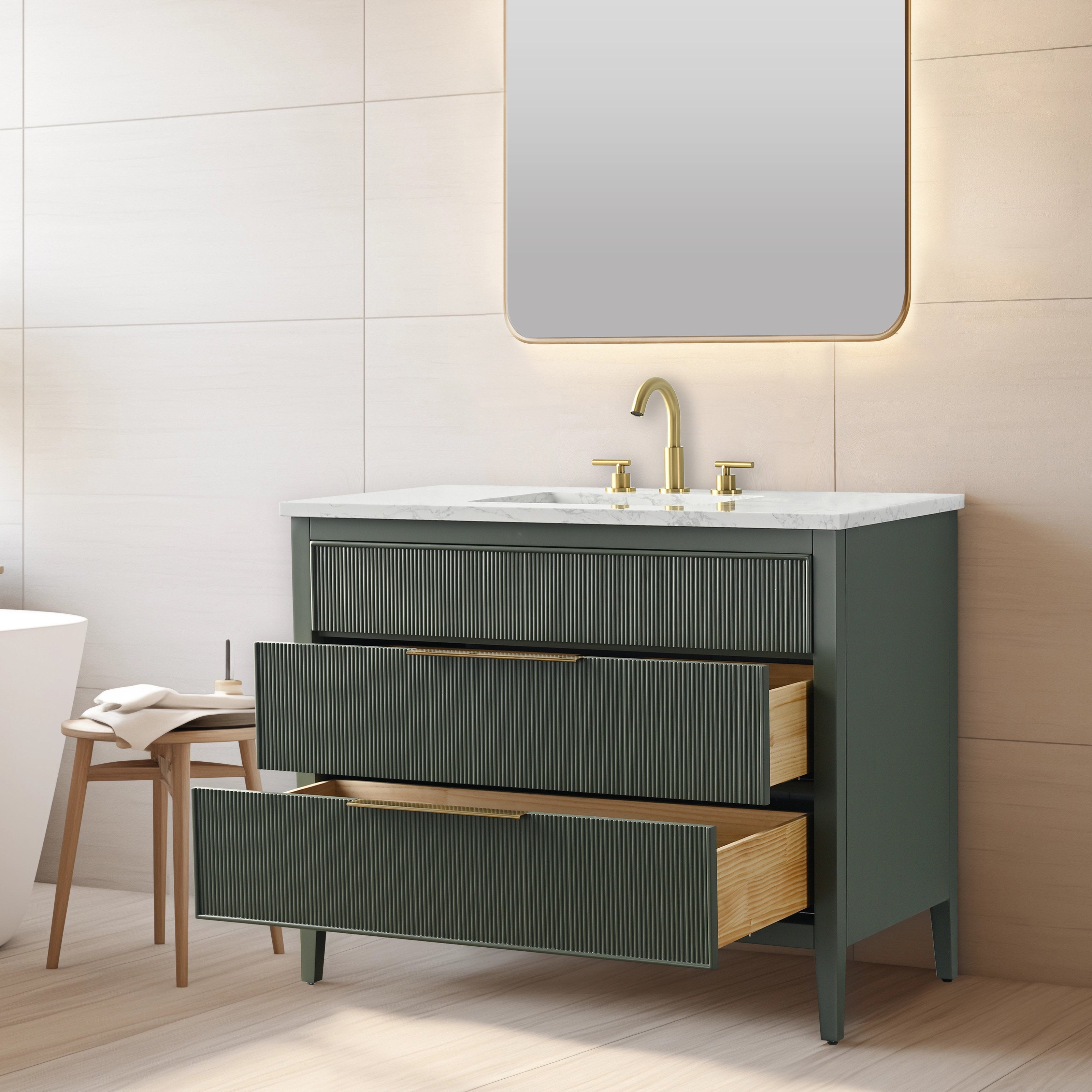 Modern single-sink bathroom vanity in stone-colored solid wood with fluted drawer fronts, white stone countertop and brass faucet; two drawers open to reveal natural wood interiors beneath a backlit mirror.