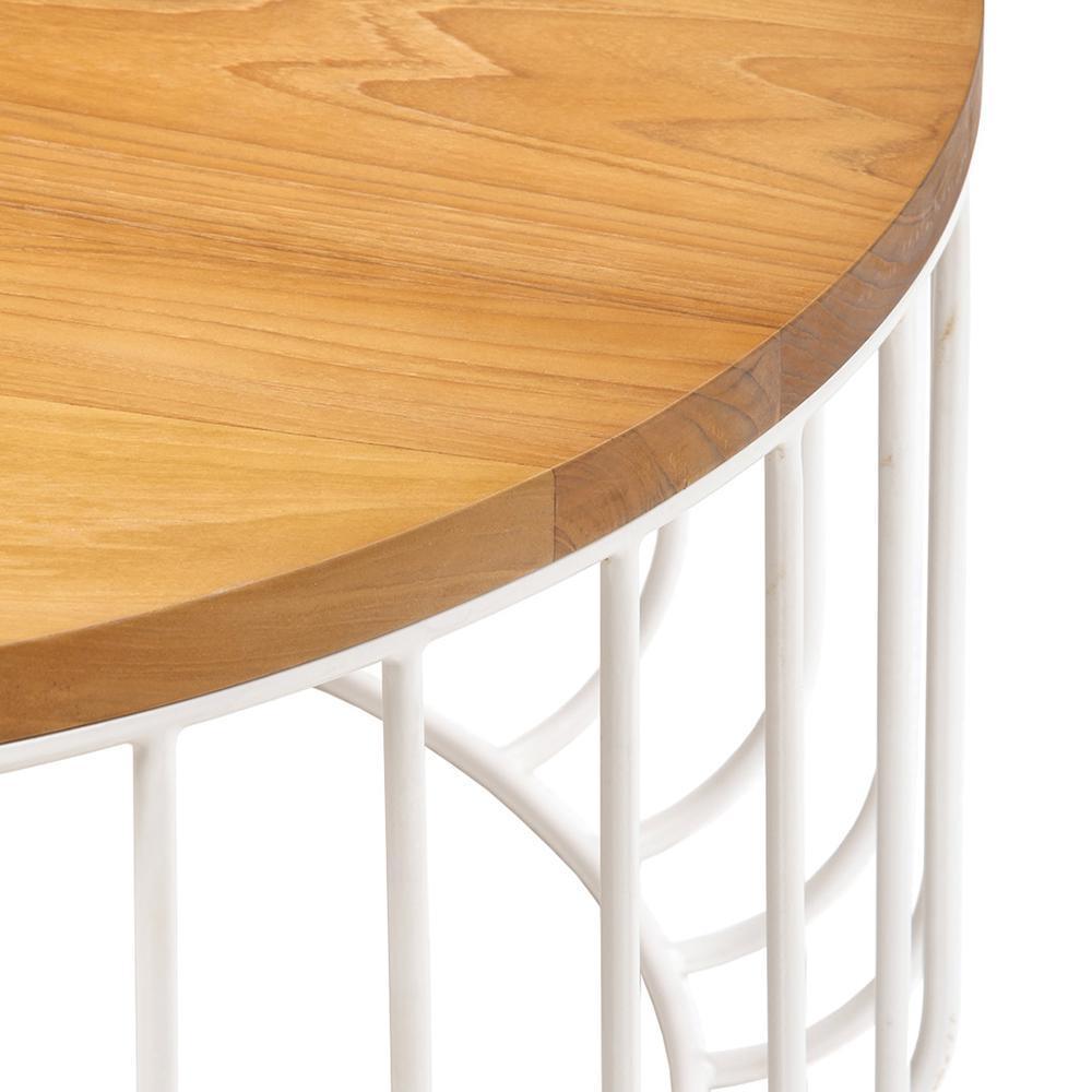 Close-up of a round teak tabletop with warm wood grain and edge detail resting on a white metal wire base with vertical curved iron supports.