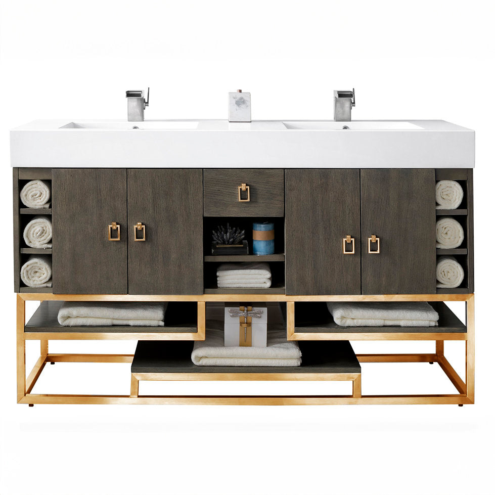 59-inch freestanding double-sink bathroom vanity with a white stone composite top and integrated rectangular sinks, stone-colored solid wood cabinet, gold metal base and square gold pulls, open shelves with rolled towels.