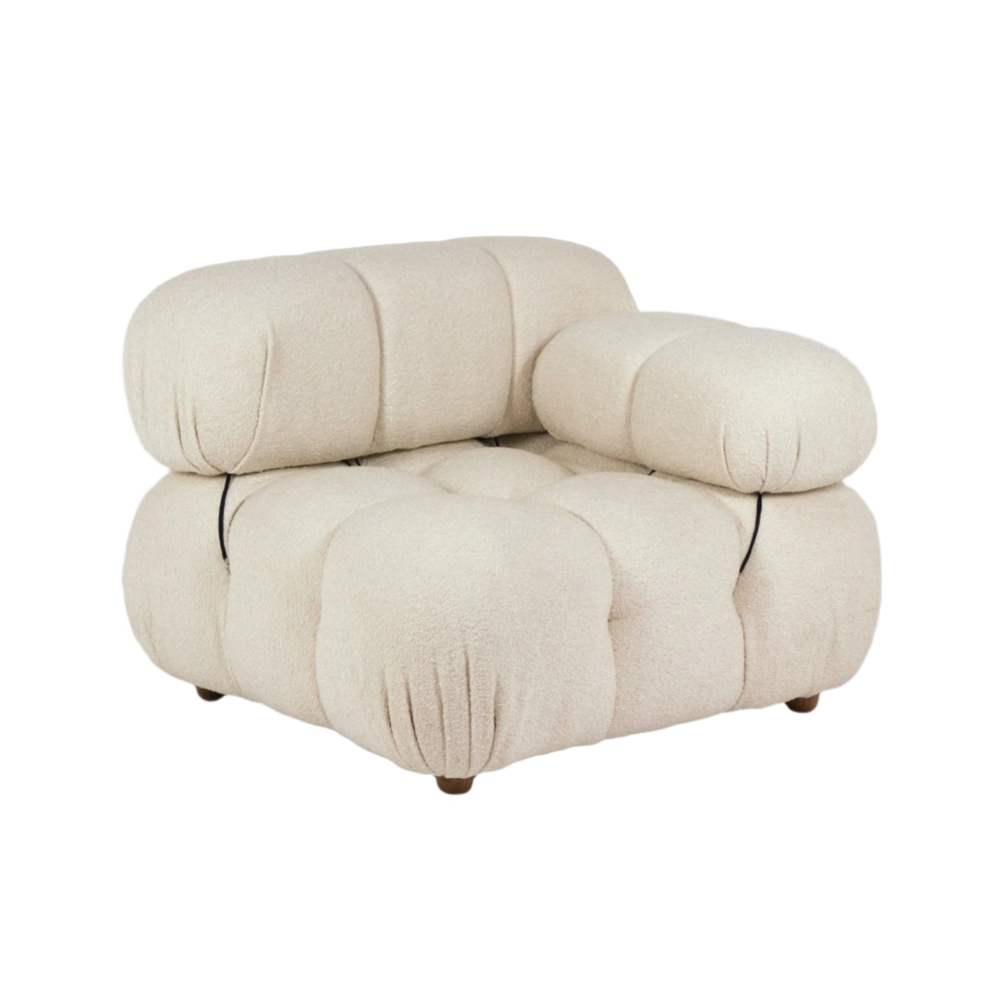 Cream boucle upholstered modern lounge chair with oversized tufted, cloud-like rounded cushions, a low rounded armrest on one side and short wooden legs.