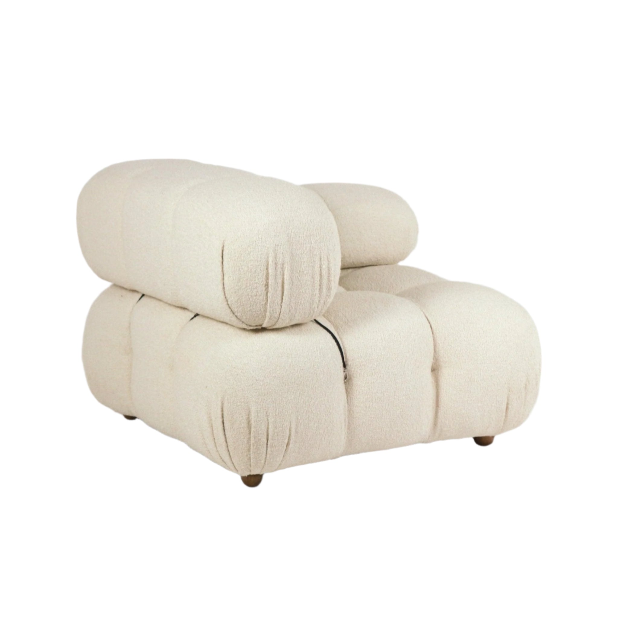 Cream boucle upholstered armless lounge chair with oversized rounded tufted cushions and low wooden legs, shown on a white background in a sculptural modern style.