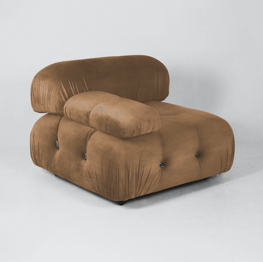 Single-seat tan leather modern lounge chair with deep button tufting, rounded pillowy cushions and low profile on short black legs, photographed on a light studio background.