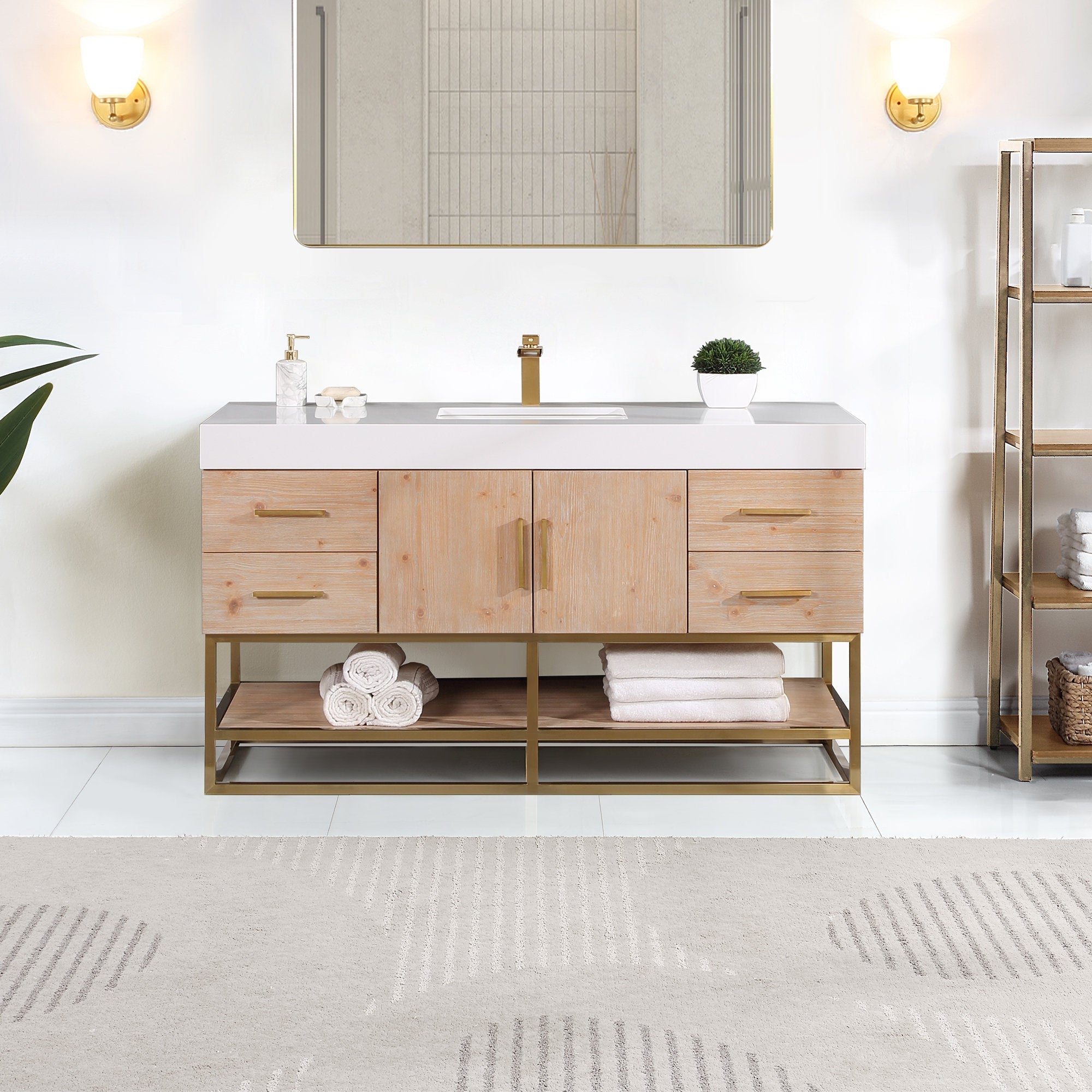 60-inch modern bathroom vanity in light natural wood with a white composite stone countertop, rectangular undermount sink, brass faucet and pulls, and open brass metal shelf holding folded towels.