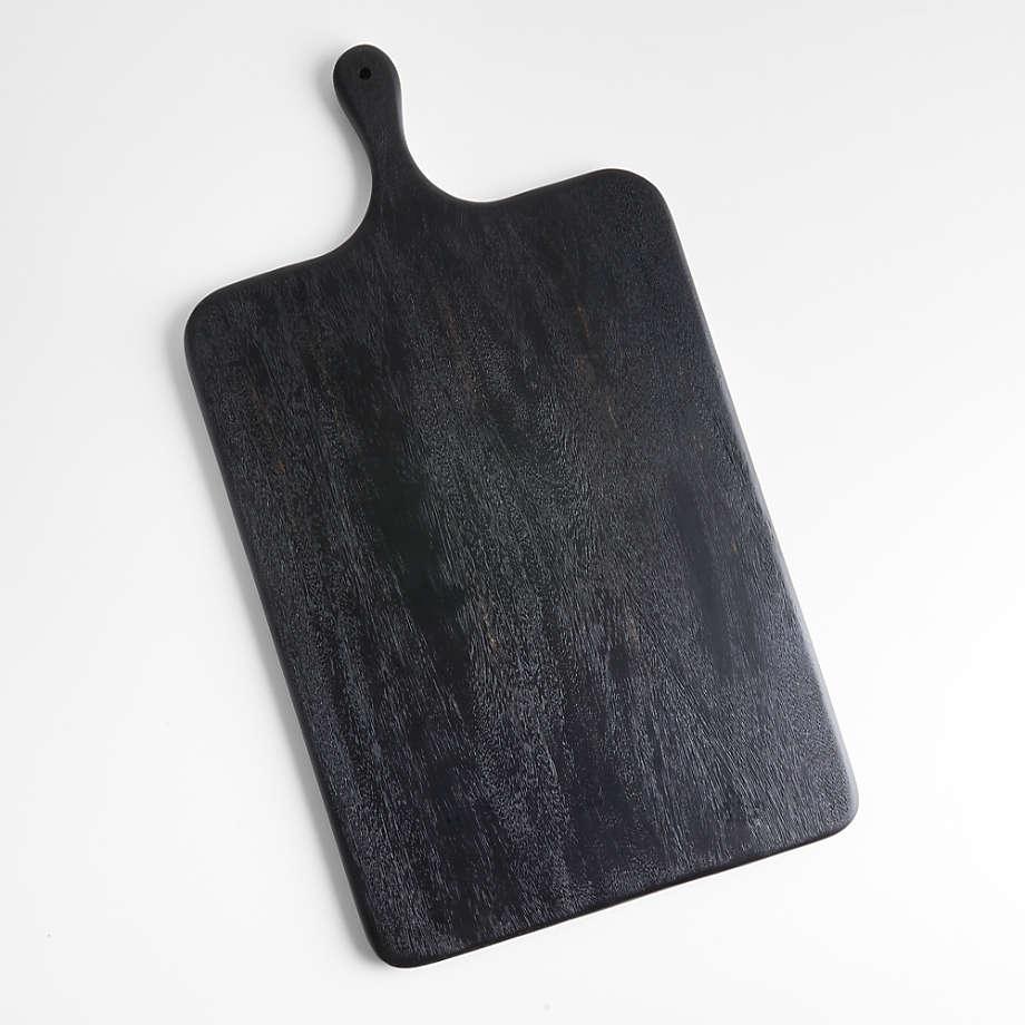Rectangular ash wood cutting board stained black with rounded corners and a small rounded handle hole, showing visible wood grain and a matte finish, photographed flat on a white background.