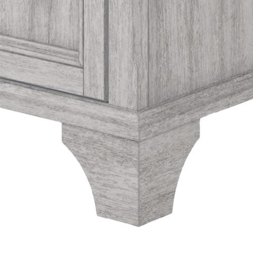 Close-up of the white solid-wood vanity corner and decorative tapered foot, showing painted wood grain, base molding and panel details on a modern freestanding bathroom vanity.