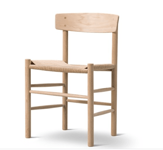 Armless dining chair in natural oak with a woven seat, low curved wooden backrest and rounded solid-wood legs, in a minimalist Scandinavian mid-century modern style on a white background.