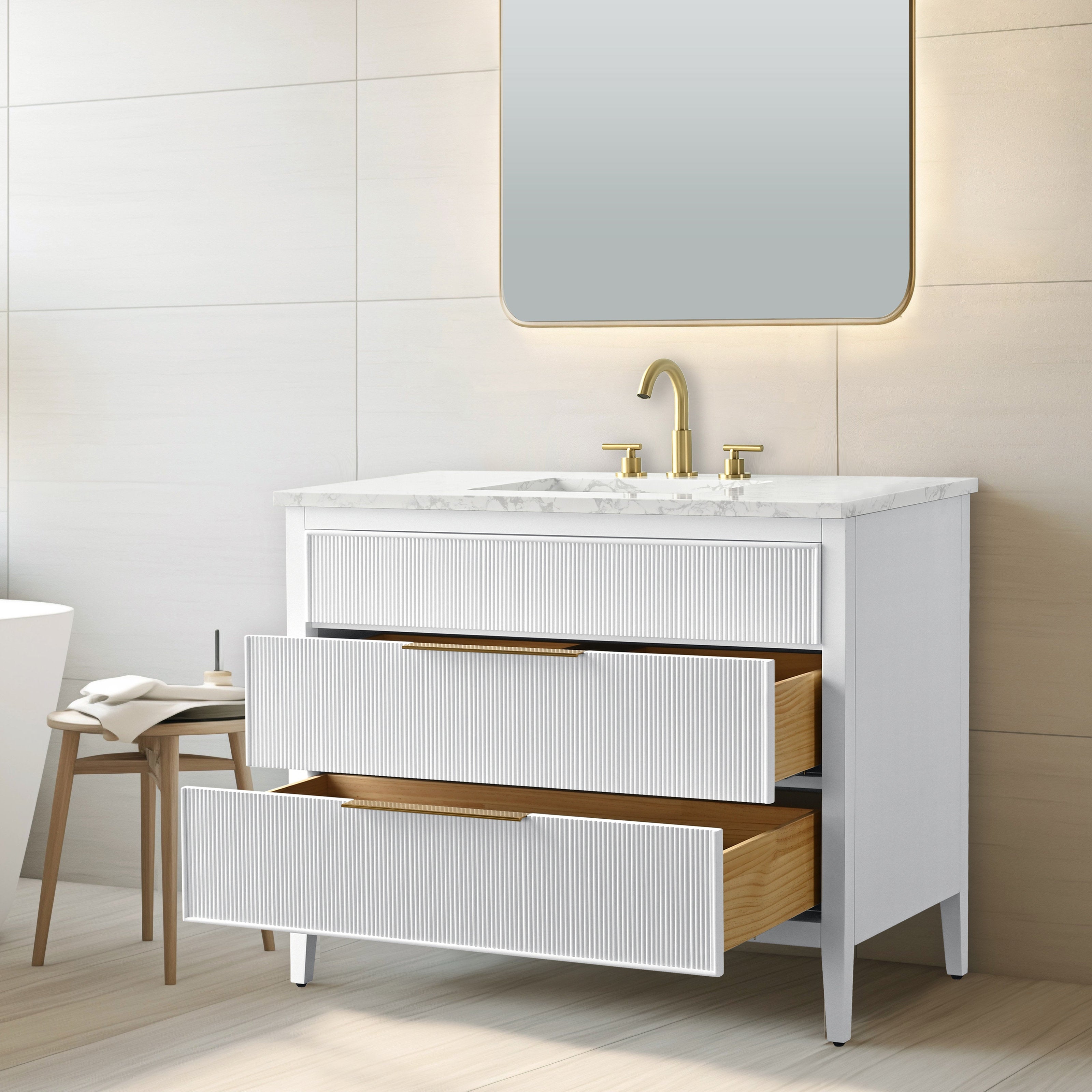 Contemporary 42-inch freestanding bathroom vanity in white solid wood with a stone marble top and single ceramic sink, gold faucet, ribbed drawer fronts and two open wood-lined drawers beneath an illuminated mirror.