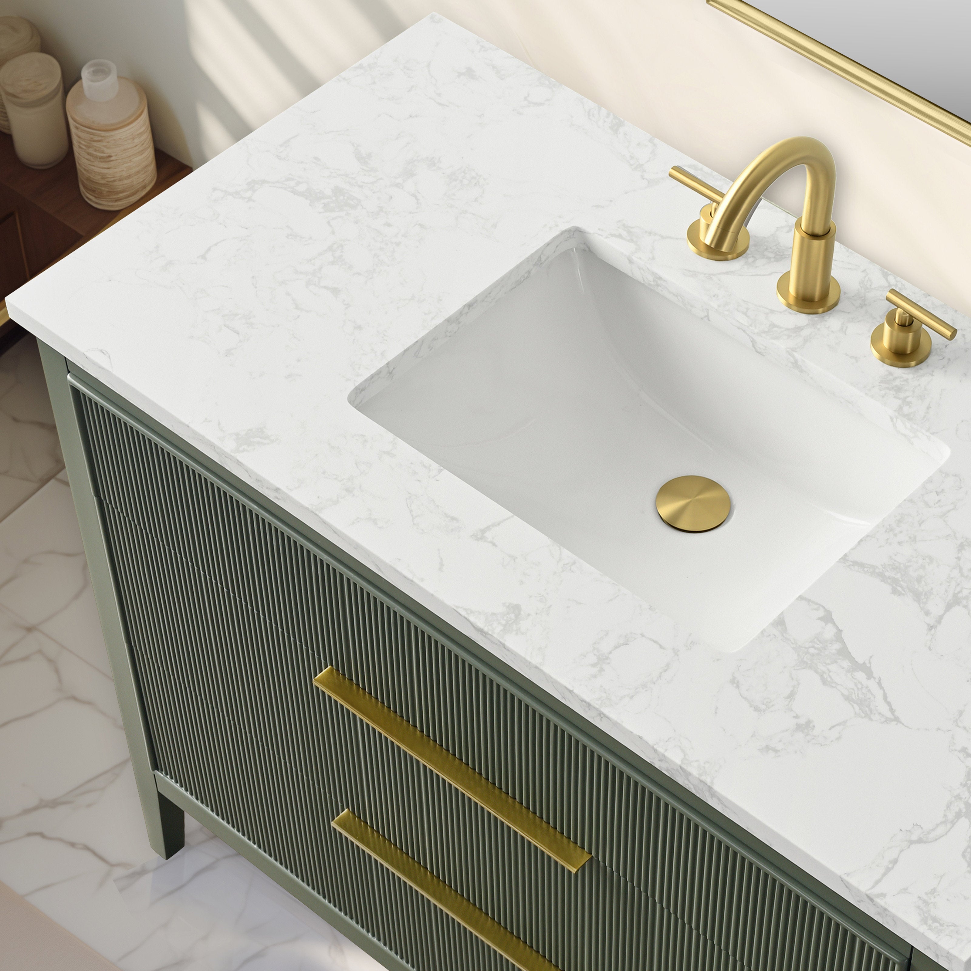 Top-down view of a modern single-sink bathroom vanity with a white stone marbled countertop, rectangular ceramic sink, brushed gold faucet and drain, and a fluted solid-wood cabinet with long gold drawer pulls.