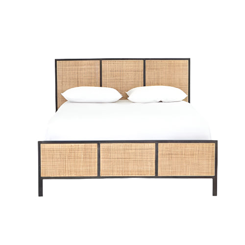Front view of a boho teak and rattan platform bed with a dark wood frame, white bedding and two pillows, featuring woven rattan panels in the headboard and footboard.