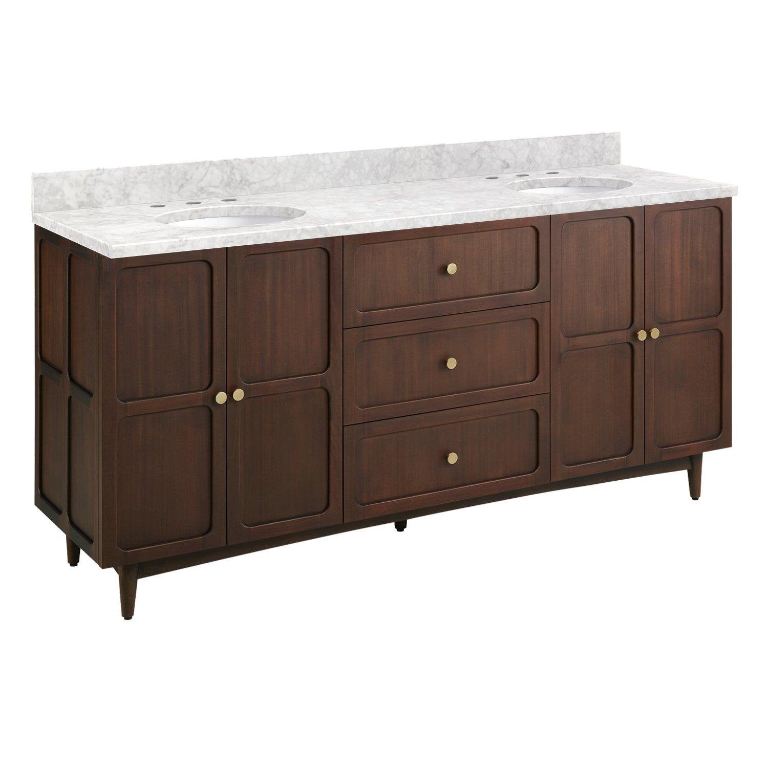 Freestanding 72-inch coastal-style double bathroom vanity in warm brown solid wood with a white Carrara marble top, two oval undermount sinks, round brass knobs and tapered legs.
