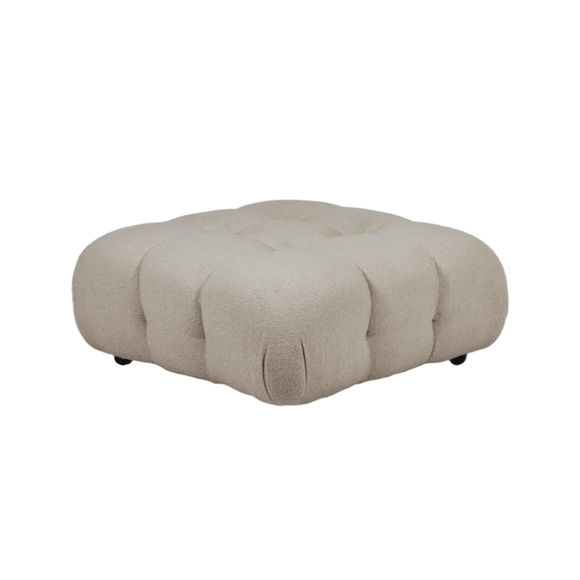 Low-profile cream boucle upholstered ottoman with deep tufted rounded sections, modern sculptural silhouette and short black legs.